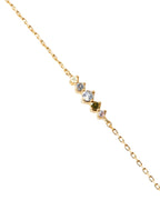 Gold necklace with small gemstones on a light gray background
